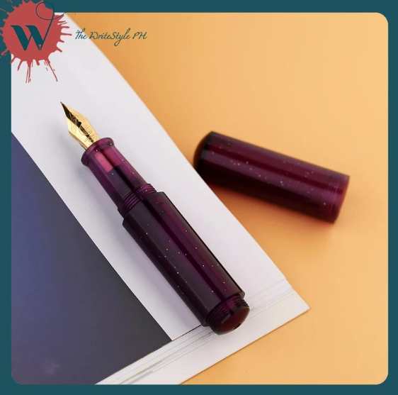 A shimmery purple acrylic mini fountain pen, opened to show the cap and the pen's nib and barrel.
