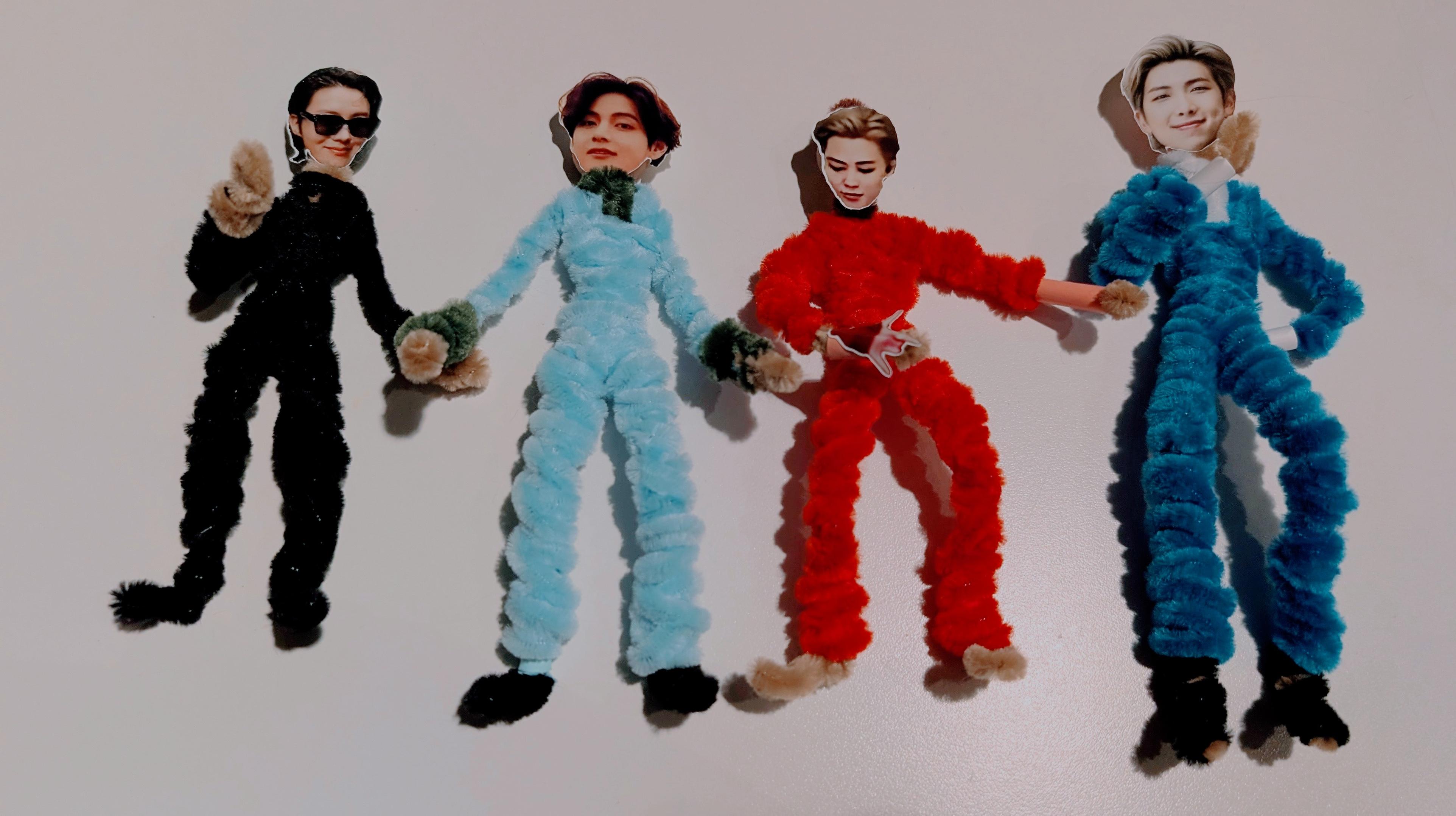 Pipe-cleaner figures of J-Hope, V, Jimin, and RM with photo cut-out faces