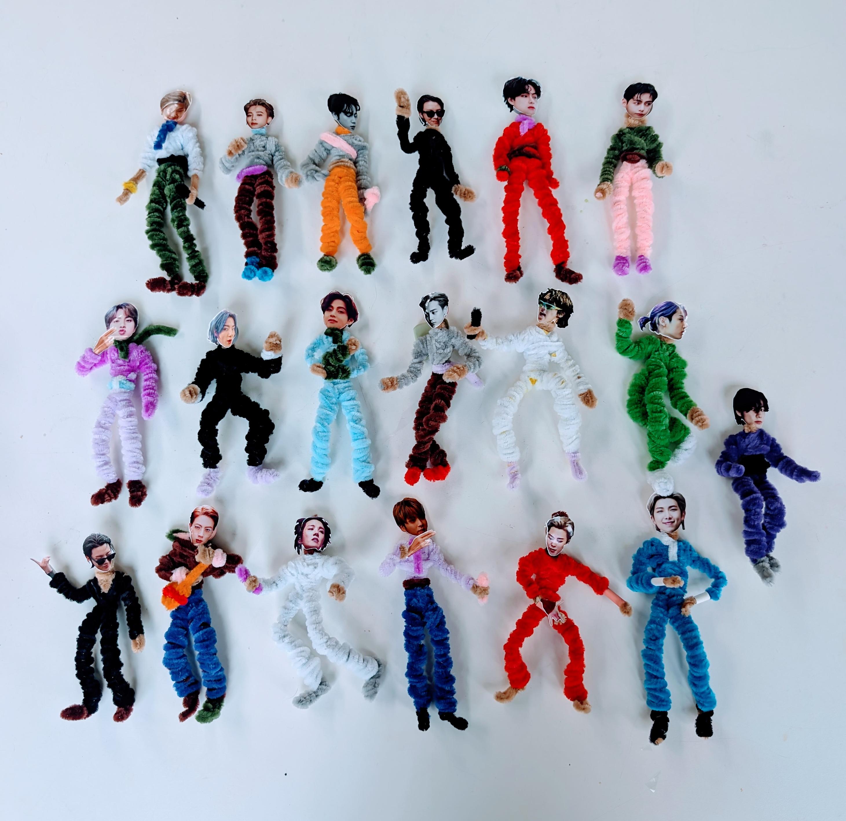 19 pipe cleaner BTS figures in various poses and outfits