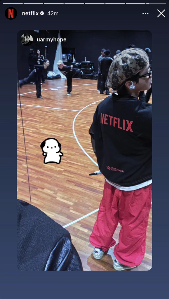 Hobi in the practice room wearing a Netflix jacket