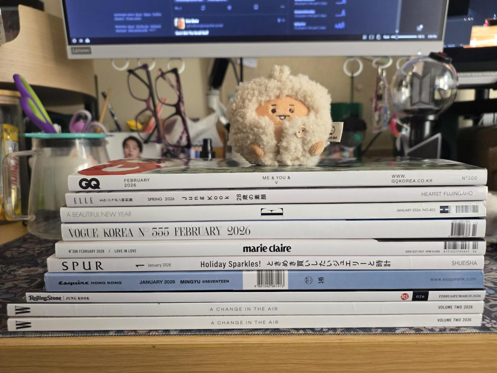 A pile of Japanese and Korean fashion magazines with a Shooky on top. Desk chaos in the background.